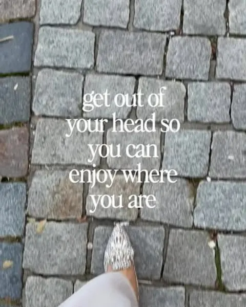 Füße auf Kopfsteinpflaster mit dem Text „get out of your head so you can enjoy where you are“.